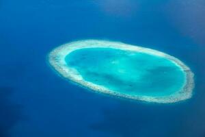 islas tropicales y atolones en maldivas desde vista aérea. famoso destino de viaje y vacaciones de lujo o concepto de vacaciones de verano. paisaje aéreo de mar azul y resorts, hoteles. Hermosa naturaleza foto