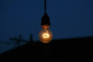 photo of yellow light bulb glowing at night