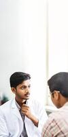 Portrait of Young Man in Lab Coat Talking with Patient in Hospital. Vertical Banner or Template Design. . photo