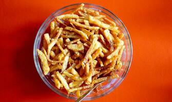 Crispy potato Fry Served in Glass Bowl with Red Background photo