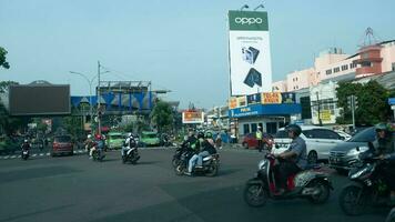 Bogor, West Java, Indonesia, May 2 2023 - Very heavy traffic of cars and motorcycle at one of the intersections of Bogor city during a sunny day. photo