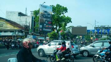 Bogor, West Java, Indonesia, May 2 2023 - Very heavy traffic of cars and motorcycle at one of the intersections of Bogor city during a sunny day. photo