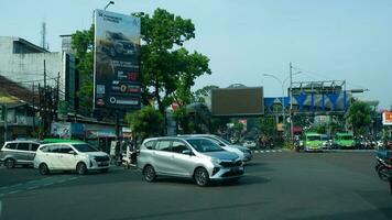 Bogor, West Java, Indonesia, May 2 2023 - Very heavy traffic of cars and motorcycle at one of the intersections of Bogor city during a sunny day. photo