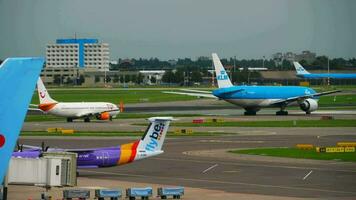 amsterdam, das Niederlande Juli 29, 2017 - - klm königlich Niederländisch Fluggesellschaften boeing 777 ph bqo rollen zu das Start und Fliege Bombenschütze Strich 8 q400 G jedm rollen nach Landung. video