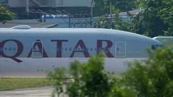 phuket, Tailandia noviembre 30, 2019 - Katar vías respiratorias boeing 777 a7 beh rodaje después aterrizaje a phuket internacional aeropuerto video
