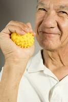 Mature man holding and squeezing massage therapy spike balls photo