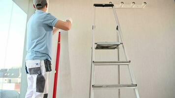 hombres aplicando vinilo fondo de pantalla en un habitación video