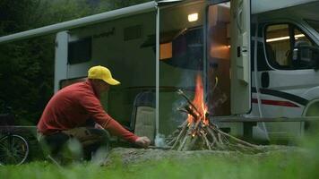 män brinnande läger brand i främre av hans husbil skåpbil husbil. familj camping tid. video