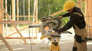 kaukasisch Konstruktion Auftragnehmer im seine 30er Jahre Arbeiten mit Leistung Werkzeug. mächtig kreisförmig Holz gesehen. industriell Thema. video