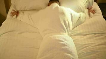 sonolento cansado caucasiano homem queda em uma hotel cama dentro lento movimento video