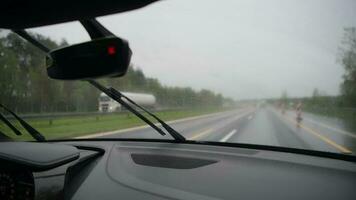 coche conducción en un autopista durante lluvioso clima. trabajando parabrisas limpiaparabrisas video