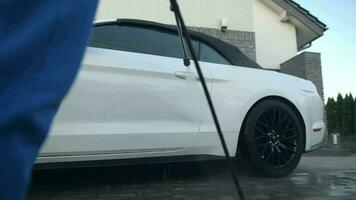 Men Washing His Modern Convertible Vehicle on His House Driveway Using Pressure Washer. video