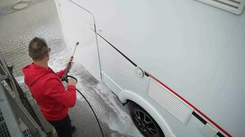 Detailed Camper Van RV Cleaning After Active Summer Season. Caucasian Men Washing His Motorhome Using Pressure Washer. video