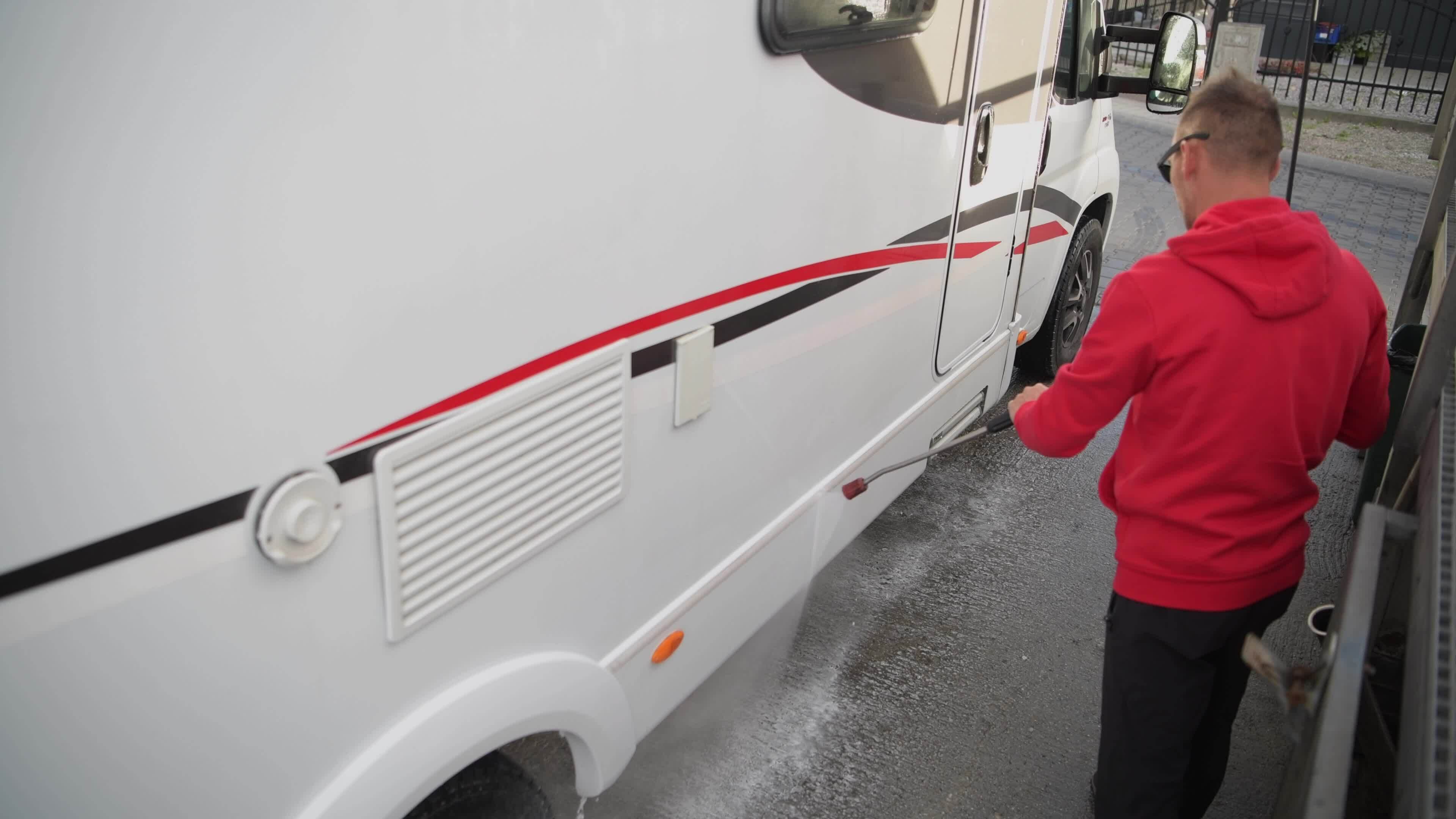Caucasian Men in His 30s Cleaning Outside His RV Camper Van Using