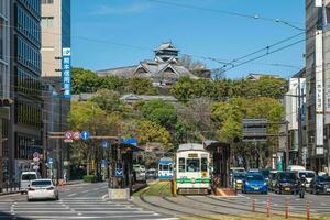 tramcar of Kumamoto City Tram stop in front of the Kumamoto castle in Kyushu, Japan. There are five lines in official count, but with only two routes regularly in service. photo