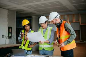Engineers are discussing data working and laptop or tablet with architectural project at new construction site on big project. photo