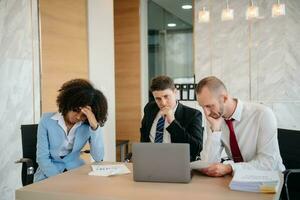 equipo pensando de problema solución a oficina reunión, triste diverso negocio personas grupo conmocionado por malo noticias, trastornado colegas foto