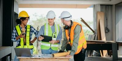 Engineers are discussing data working and laptop or tablet with architectural project at new construction site on big project. photo