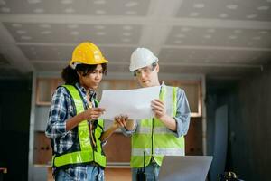 Engineers are discussing data working and laptop or tablet with architectural project at new construction site on big project. photo