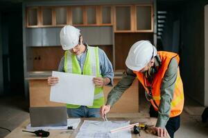Engineers are discussing data working and laptop or tablet with architectural project at new construction site on big project. photo
