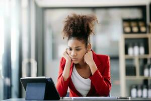 Asian business woman is stressed, bored, and overthinking from working on a tablet at the modern office. photo