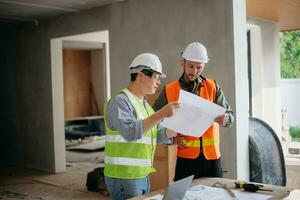 Engineers are discussing data working and laptop or tablet with architectural project at new construction site on big project. photo