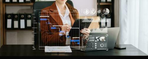 Businessman hand Project manager working and update tasks and Gantt chart scheduling virtual diagram.with smart phone, tablet and laptop photo