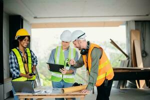 Engineers are discussing data working and laptop or tablet with architectural project at new construction site on big project. photo