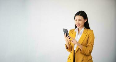 Portrait photo of young beautiful Asian woman feeling happy and holding smart phone, tablet and laptop with black empty screen on white background can use for advertising or product concept.