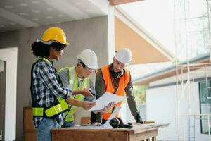 Engineers are discussing data working and laptop or tablet with architectural project at new construction site on big project. photo