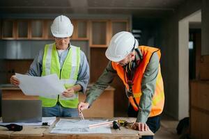 Engineers are discussing data working and laptop or tablet with architectural project at new construction site on big project. photo