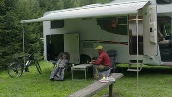 kaukasisch Familie beim das Tabelle im Vorderseite von Wohnmobil rv Wohnmobil van Ausgaben großartig Zeit zusammen. video