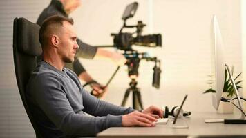 Caucasian Office Worker in Front of Desktop Computer Inside Video Production Studio