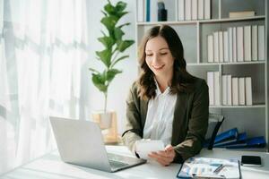 una mujer independiente está trabajando en su trabajo en una tableta de computadora y una computadora portátil haciendo un informe de análisis contable de datos de inversión inmobiliaria, financieros en la oficina foto