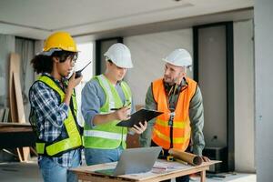 Engineers are discussing data working and laptop or tablet with architectural project at new construction site on big project. photo
