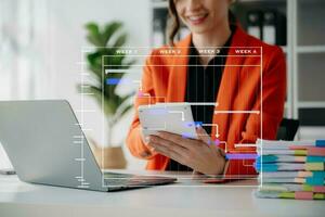 gerente de proyecto trabajando y actualizando tareas con hitos de planificación de progreso y diagrama de programación de diagramas de gantt. negocios que trabajan con teléfonos inteligentes, tabletas y computadoras portátiles foto