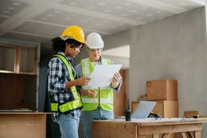 Engineers are discussing data working and laptop or tablet with architectural project at new construction site on big project. photo