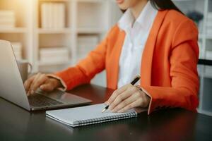 Businesswoman hand using laptop, tablet and smartphone in office. Digital marketing media mobile app and discussing plan new start up project. Finance task. photo