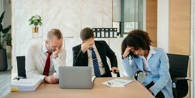 Team thinking of problem solution at office meeting, sad diverse business people group shocked by bad news, upset colleagues photo