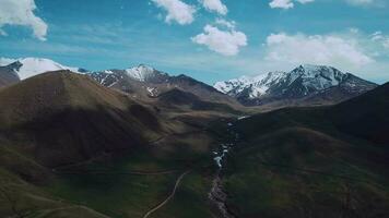 tierras altas con nubes y nevadas picos, aéreo ver video