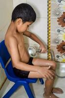linda indio chico teniendo bañera durante el verano vacaciones estación, linda asiático niño Lavado en un baño, niño baños estilo de vida concepto foto