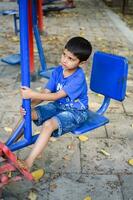 asiático chico haciendo rutina ejercicio en sociedad parque durante el Mañana tiempo. linda pequeño niño ejercicio y gimnasio a mantener él mismo ajuste para vida. niño ejercicio al aire libre disparar foto