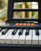 de cerca de piano llaves. piano negro y blanco llaves y piano teclado musical instrumento metido a el hogar balcón durante soleado día. foto