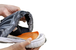 Hand holding an old, broken black shoe behind the heel of the shoe on transparent background png
