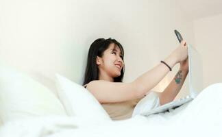 Working in bed in the morning with laptop submitting work online talk online communicate online concept of working on vacation photo