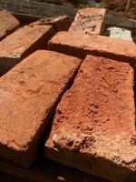 Close-up photo of a pile of bricks on the construction site. Construction of a new house. A pile of building materials, a stack of red bricks for construction is put together.