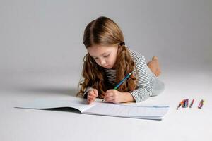 retrato de un pequeño niña de eslavo apariencia quien lo hace su tarea. sitio para texto foto