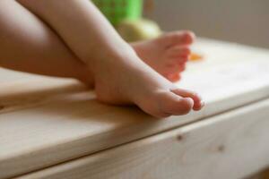 baby's feet on a wooden table with fruit close-up photo