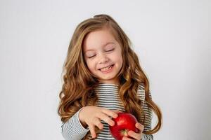retrato de un pequeño contento niña de eslavo apariencia comiendo un rojo manzana. sitio para texto foto