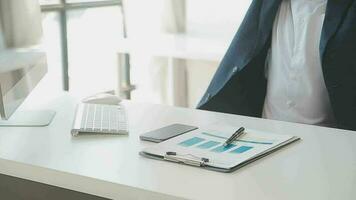 Close up Business woman using calculator and laptop for do math finance on wooden desk, tax, accounting, statistics and analytical research concept video